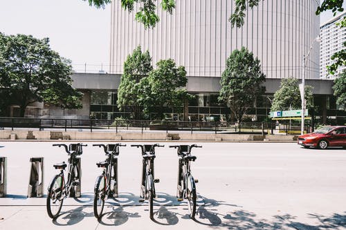 四辆黑停在路边的自行车 · 免费素材图片