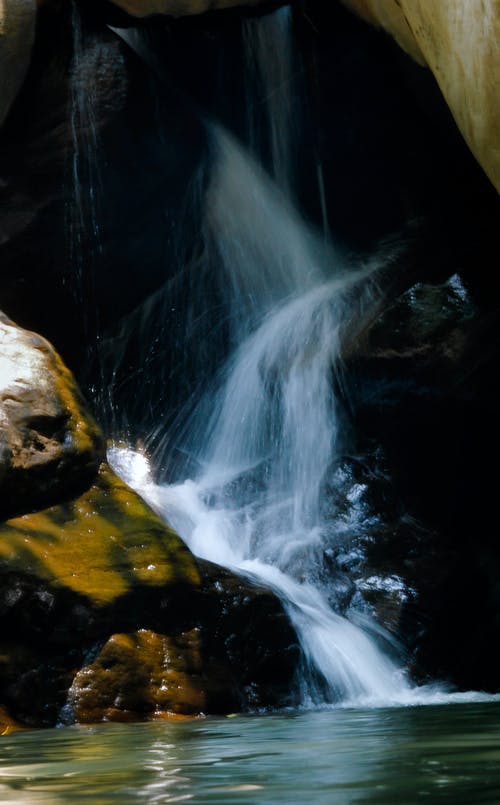 布朗岩石之间的自来水照片 · 免费素材图片