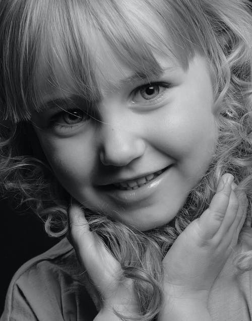 微笑女孩的灰度照片 · 免费素材图片