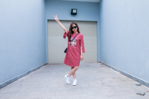 穿红色长袖的裙子站在百叶窗门前的女人 · 免费素材图片