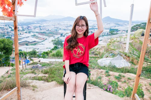 女人穿着红色的衬衫和黑色的短裤 · 免费素材图片