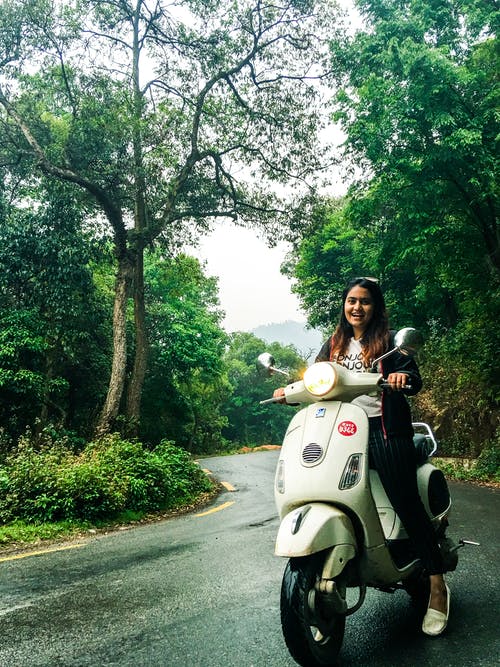 摩托车上的女人穿白色圆领衬衫 · 免费素材图片