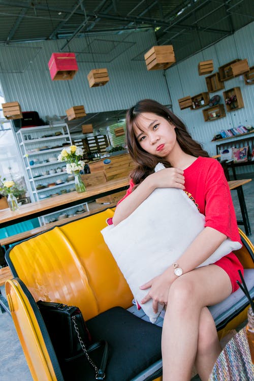 女人坐在黄色的沙发上 · 免费素材图片