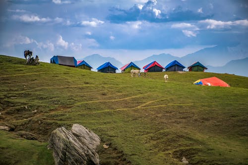 拍摄在绿草山上的衬帐篷 · 免费素材图片