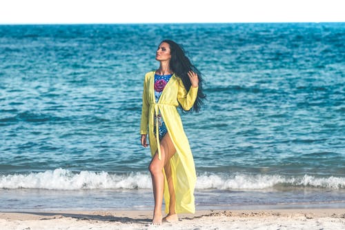 女人穿着蓝色monokini站在沙滩上 · 免费素材图片