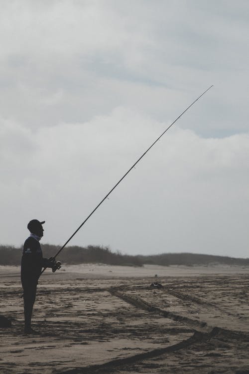 男子站着一根钓鱼竿 · 免费素材图片