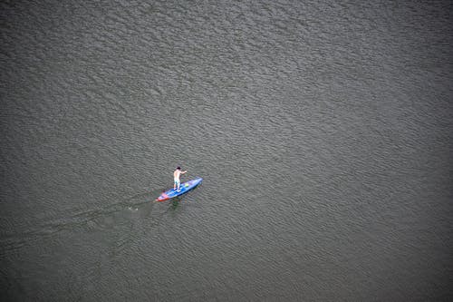 在水面上骑蓝色和红色戒尺的人 · 免费素材图片