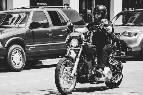 男子骑摩托车的灰度照片 · 免费素材图片