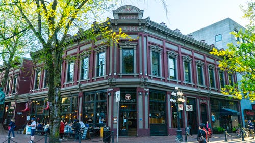 一群人在灰色和粉红色的混凝土建筑附近 · 免费素材图片