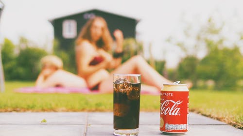 可口可乐罐和装可乐的水杯 · 免费素材图片