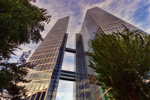在湛蓝的天空下的两个透明玻璃摩天大楼的低角度照片 · 免费素材图片