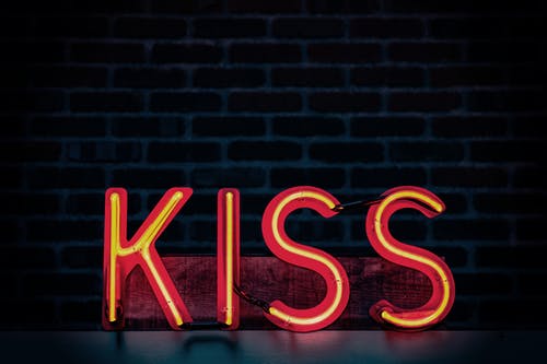 黑暗点燃房间的红色亲吻霓虹灯标牌 · 免费素材图片