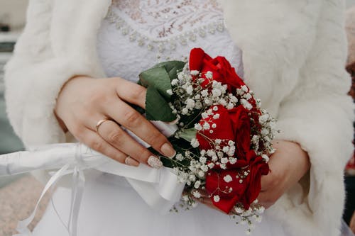 女人抱着红玫瑰花束 · 免费素材图片