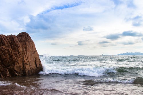 海浪溅在岸边和岩石岛 · 免费素材图片