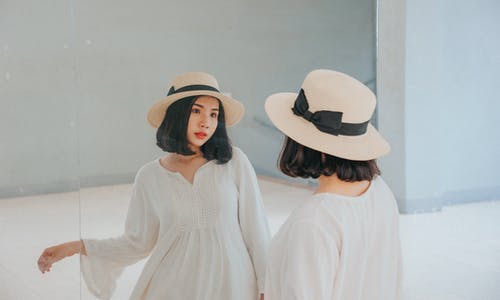 女人穿着白色长袖连衣裙和米色太阳帽 · 免费素材图片