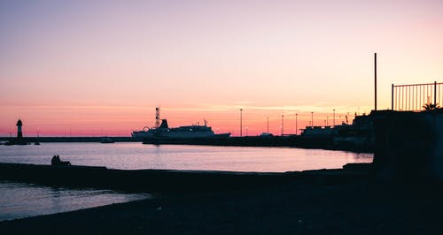 黎明时分在水附近的船坞的轮廓 · 免费素材图片