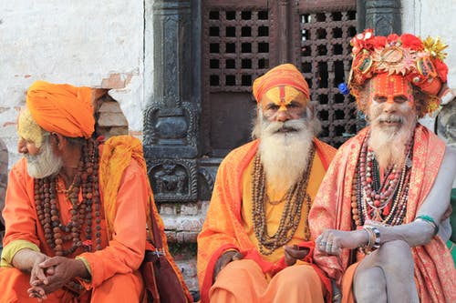 三名男子穿着橙色传统服装 · 免费素材图片