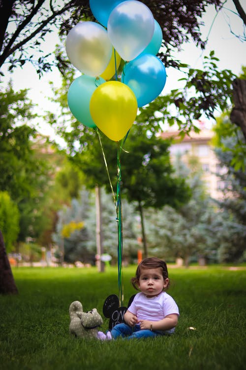 婴儿与蓝色和黄色的气球 · 免费素材图片