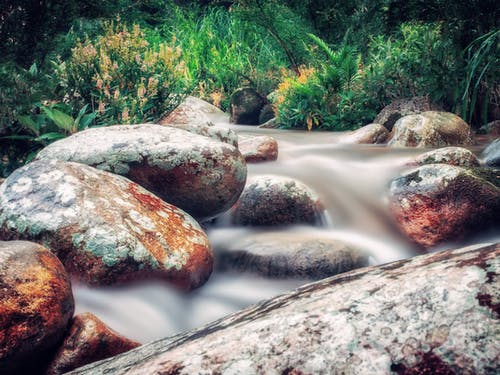 岩石上流淌的河流的延时照片 · 免费素材图片