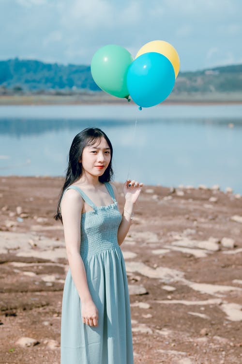 一个拿着气球的女人的摄影 · 免费素材图片