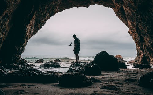 站在海边岩石上的人的照片 · 免费素材图片