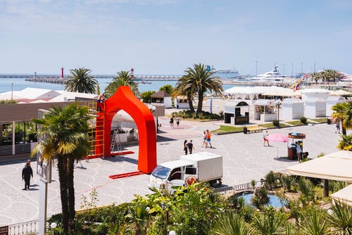 白盒货车停在人和植物附近 · 免费素材图片