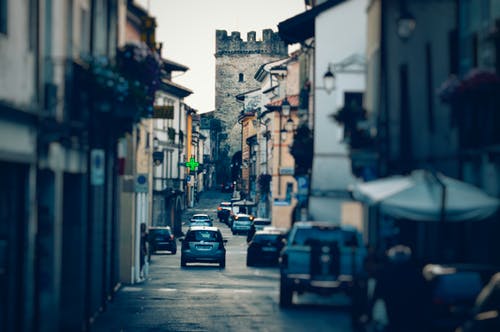 村庄之间的银色车辆的景深摄影 · 免费素材图片