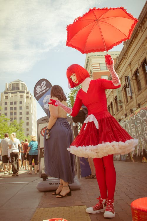 女人穿着红色的衣服，拿着伞 · 免费素材图片