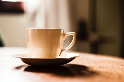 白色陶瓷茶杯与茶碟木制的桌子上 · 免费素材图片