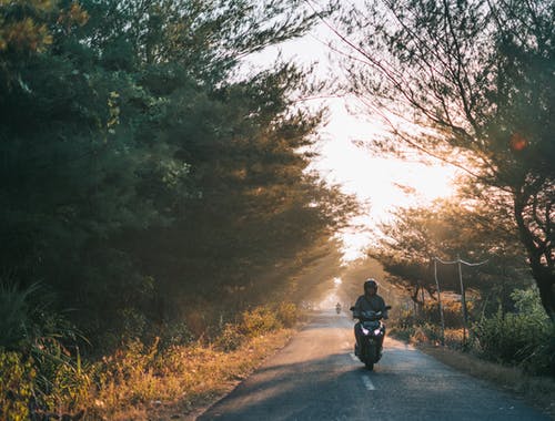 男人穿着灰色衬衫骑摩托车 · 免费素材图片