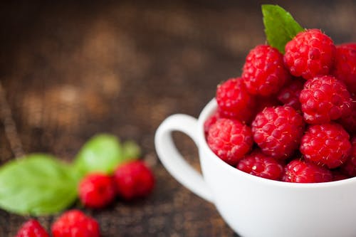 倾斜移位摄影中的白色茶杯中的成熟树莓 · 免费素材图片
