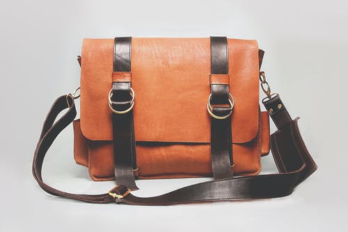 橙色和黑色皮革挎包 · 免费素材图片