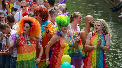 三人穿着彩虹裙在人群中跳舞 · 免费素材图片