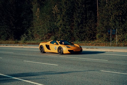 橙色跑车在沥青路面上的浅焦点摄影 · 免费素材图片
