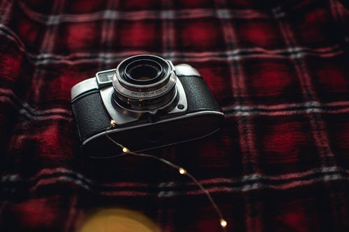 黑色，灰色傻瓜相机在红色，黑色和白色格子纺织物上 · 免费素材图片