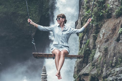 女人在瀑布前荡秋千的照片 · 免费素材图片