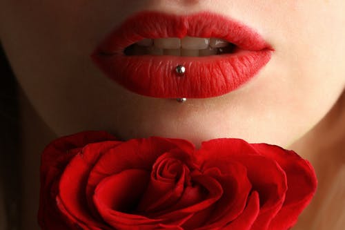 女人穿着红色玫瑰附近的红色唇膏 · 免费素材图片