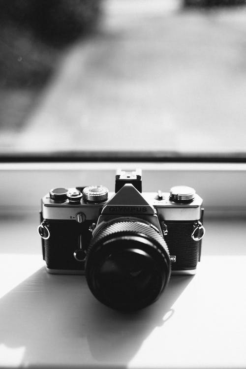 奥林巴斯单反相机在镜子附近的灰度摄影 · 免费素材图片
