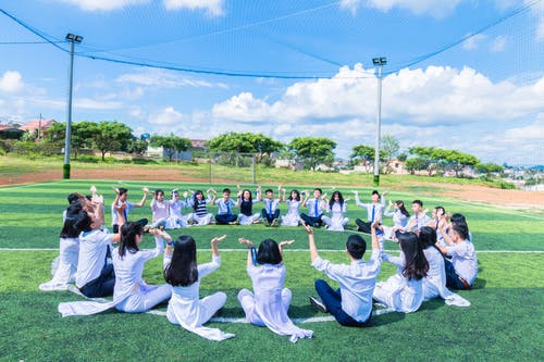 人们坐在绿草地上 · 免费素材图片