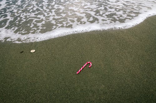 在沙滩上的白色和红色圣诞糖果 · 免费素材图片