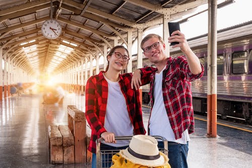 男人和女人在火车站采取自拍照 · 免费素材图片