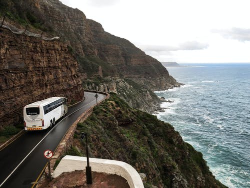 悬崖附近道路上的白色巴士 · 免费素材图片