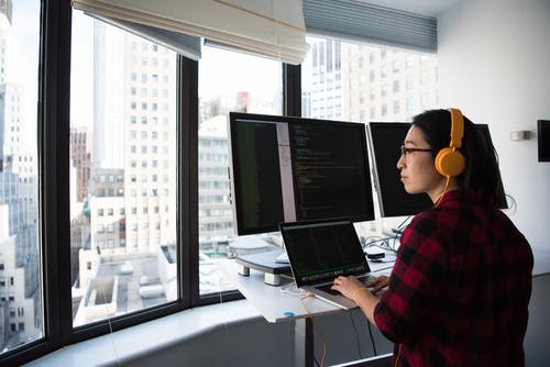 女人坐在同时操作macbook Pro · 免费素材图片