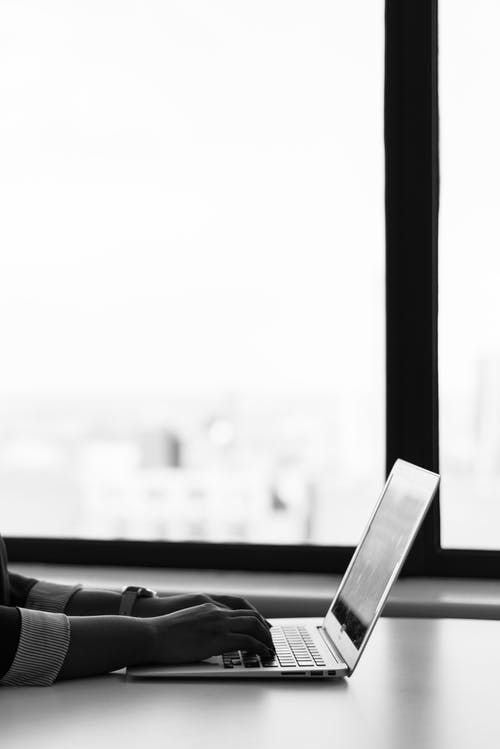 白色表面上的灰色笔记本电脑 · 免费素材图片