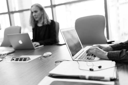 使用便携式计算机的人的灰度照片 · 免费素材图片