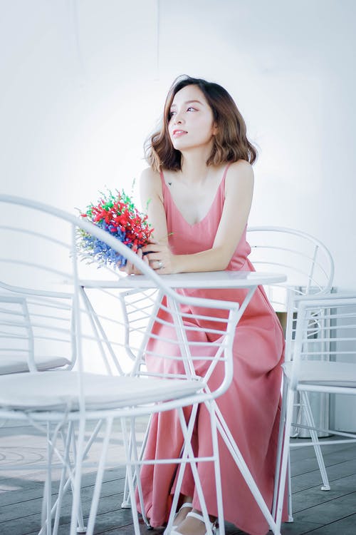 坐在椅子上的粉红色裙子的女人 · 免费素材图片