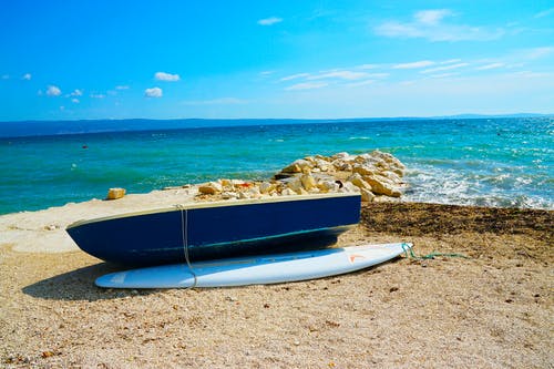 在水体旁边的蓝色木制小艇船 · 免费素材图片