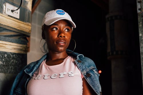 女人穿着白帽子和粉红色的圆领衬衫 · 免费素材图片