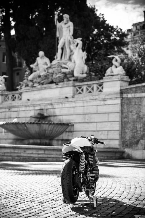 摩托车在雕像附近的灰度摄影 · 免费素材图片