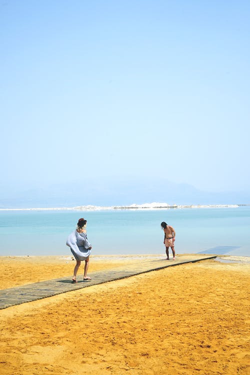 两人站在沙滩上 · 免费素材图片